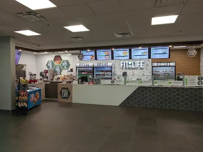 The Fit For Life Cafe service counter in Waterloo, with digital menu boards and the build-your-own bowl line